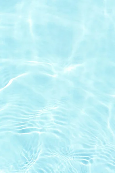 水面上有波纹的蓝色水 Defocus模糊了透明的蓝色清晰平静的水面纹理与水花和气泡 具有闪光图案纹理背景的水波 图库图片