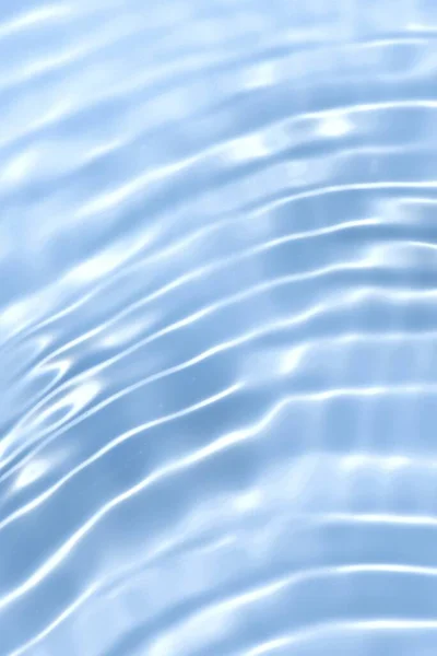 水面上有波纹的蓝色水 Defocus模糊了透明的蓝色清晰平静的水面纹理与水花和气泡 具有闪光图案纹理背景的水波 免版税图库照片