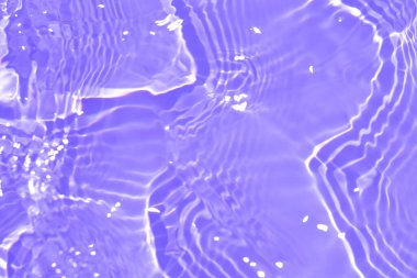 Yüzeyinde dalgalanmalar olan mor bir su. Defocus bulanık, şeffaf pembe, berrak, durgun su yüzeyi dokusu, sıçrama ve kabarcıklarla bulanıklaştırılmış. Parlak desenli arka planda su dalgaları.