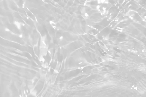 stock image White water with ripples on the surface. Defocus blurred transparent white colored clear calm water surface texture with splashes and bubbles. Water waves with shining pattern texture background.