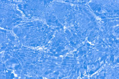 Yüzeyinde dalgalanmalar olan mavi su. Defocus bulanık mavi şeffaf, berrak, durgun su yüzeyi dokusu sıçrama ve kabarcıklarla bulanıklaştırılmış. Parlak desenli arka planda su dalgaları.