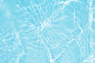 Yüzeyinde dalgalanmalar olan mavi su. Defocus bulanık mavi şeffaf, berrak, durgun su yüzeyi dokusu sıçrama ve kabarcıklarla bulanıklaştırılmış. Parlak desenli arka planda su dalgaları.
