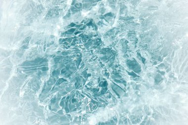 Defocus bulanık mavi şeffaf, berrak, durgun su yüzeyi dokusu sıçrama ve kabarcıklarla bulanıklaştırılmış. Moda soyut doğa geçmişi. Güneş ışığında fotokopi uzayıyla birlikte su dalgaları. Mavi suluboya parlıyor