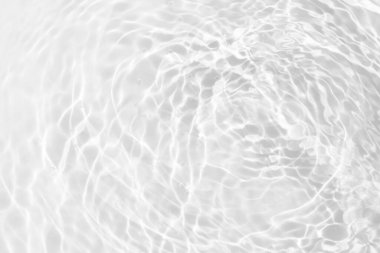 Yüzeyinde dalgalanmalar olan beyaz su. Defocus bulanık şeffaf beyaz renkli berrak sakin su yüzeyi dokusu sıçrama ve kabarcıklarla. Parlak desenli arka planda su dalgaları.