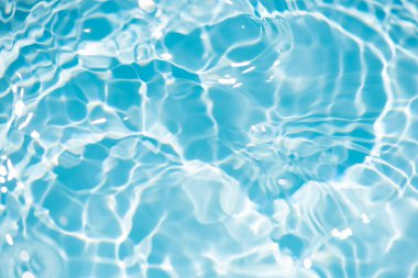 Defocus bulanık mavi şeffaf, berrak, durgun su yüzeyi dokusu sıçrama ve kabarcıklarla bulanıklaştırılmış. Moda soyut doğa geçmişi. Güneş ışığında fotokopi uzayıyla birlikte su dalgaları. Mavi suluboya parlıyor