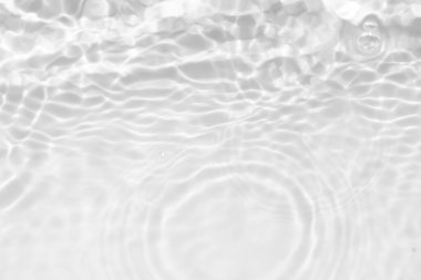 Yüzeyinde dalgalanmalar olan beyaz su. Defocus bulanık şeffaf beyaz renkli berrak sakin su yüzeyi dokusu sıçrama ve kabarcıklarla. Parlak desenli arka planda su dalgaları.