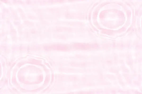 Pink water splashes on the surface ripple blur. Defocus blurred transparent pink colored clear calm water surface texture with splash and bubble. Water waves with shining pattern texture background
