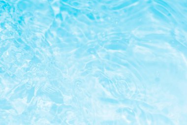 Yüzeydeki mavi su dalgaları bulanıklaştı. Defocus bulanık mavi şeffaf, berrak, durgun su yüzeyi dokusu sıçrama ve kabarcıklarla bulanıklaştırılmış. Parlak desenli arka planda su dalgaları.