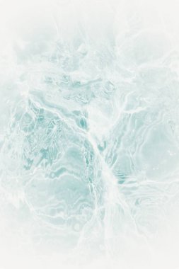 Yüzeydeki mavi su dalgaları bulanıklaştı. Defocus bulanık mavi şeffaf, berrak, durgun su yüzeyi dokusu sıçrama ve kabarcıklarla bulanıklaştırılmış. Parlak desenli arka planda su dalgaları.