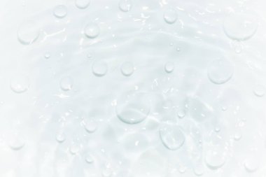 Yüzeydeki mavi su dalgaları bulanıklaştı. Defocus bulanık mavi şeffaf, berrak, durgun su yüzeyi dokusu sıçrama ve kabarcıklarla bulanıklaştırılmış. Parlak desenli arka planda su dalgaları.