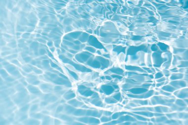 Yüzeydeki mavi su dalgaları bulanıklaştı. Defocus bulanık mavi şeffaf, berrak, durgun su yüzeyi dokusu sıçrama ve kabarcıklarla bulanıklaştırılmış. Parlak desenli arka planda su dalgaları.