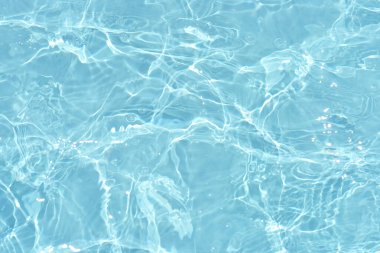 Yüzeydeki mavi su dalgaları bulanıklaştı. Defocus bulanık mavi şeffaf, berrak, durgun su yüzeyi dokusu sıçrama ve kabarcıklarla bulanıklaştırılmış. Parlak desenli arka planda su dalgaları.