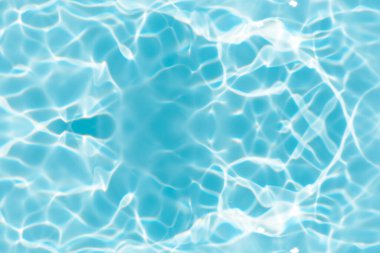 Yüzeydeki mavi su dalgaları bulanıklaştı. Defocus bulanık mavi şeffaf, berrak, durgun su yüzeyi dokusu sıçrama ve kabarcıklarla bulanıklaştırılmış. Parlak desenli arka planda su dalgaları.