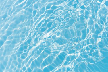 Yüzeydeki mavi su dalgaları bulanıklaştı. Defocus bulanık mavi şeffaf, berrak, durgun su yüzeyi dokusu sıçrama ve kabarcıklarla bulanıklaştırılmış. Parlak desenli arka planda su dalgaları.