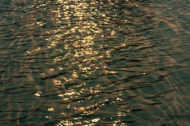 Yüzeydeki mavi su dalgaları bulanıklaştı. Defocus bulanık mavi şeffaf, berrak, durgun su yüzeyi dokusu sıçrama ve kabarcıklarla bulanıklaştırılmış. Parlak desenli arka planda su dalgaları.