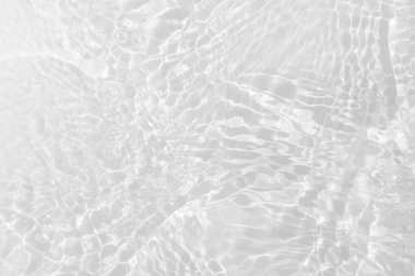 Yüzeydeki mavi su dalgaları bulanıklaştı. Defocus bulanık mavi şeffaf, berrak, durgun su yüzeyi dokusu sıçrama ve kabarcıklarla bulanıklaştırılmış. Parlak desenli arka planda su dalgaları.