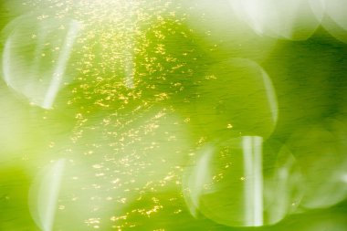 Yüzeydeki mavi su dalgaları bulanıklaştı. Defocus bulanık mavi şeffaf, berrak, durgun su yüzeyi dokusu sıçrama ve kabarcıklarla bulanıklaştırılmış. Parlak desenli arka planda su dalgaları.