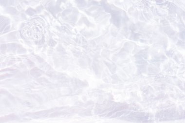 Yüzeydeki mavi su dalgaları bulanıklaştı. Defocus bulanık mavi şeffaf, berrak, durgun su yüzeyi dokusu sıçrama ve kabarcıklarla bulanıklaştırılmış. Parlak desenli arka planda su dalgaları.