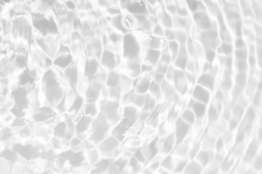 Yüzeyinde dalgalanmalar olan mavi su. Defocus bulanık mavi şeffaf, berrak, durgun su yüzeyi dokusu sıçrama ve kabarcıklarla bulanıklaştırılmış. Parlak desenli arka planda su dalgaları.