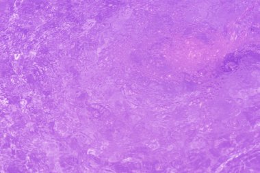 Yüzeyinde dalgalanmalar olan mavi su. Defocus bulanık mavi şeffaf, berrak, durgun su yüzeyi dokusu sıçrama ve kabarcıklarla bulanıklaştırılmış. Parlak desenli arka planda su dalgaları.