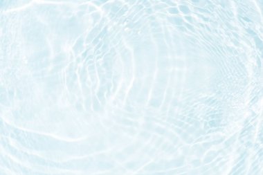 Yüzeydeki mavi su dalgaları bulanıklaştı. Defocus bulanık mavi şeffaf, berrak, durgun su yüzeyi dokusu sıçrama ve kabarcıklarla bulanıklaştırılmış. Parlak desenli arka planda su dalgaları.