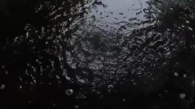 Geceleri kaldırım taşlarında yavaş yağmur damlaları, yağmur mevsimi konsepti. 4k görüntü kalitesi