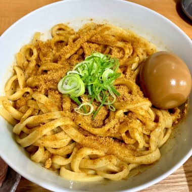 Close up ramen noodles with egg are provided in white bowls. Delicious food concept. Top view.