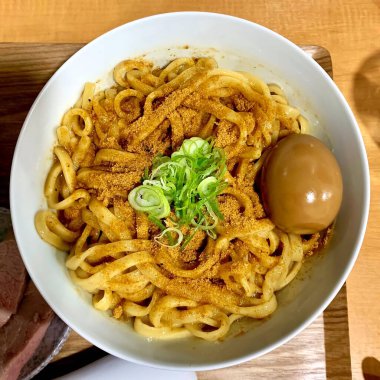 Close up ramen noodles with egg are provided in white bowls. Delicious food concept. Top view.