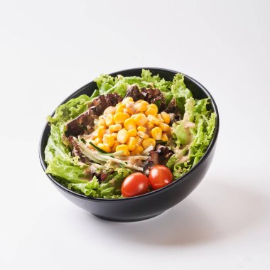 Close up healthy vegetables in black bowl isolated on white background. Healthy food concept