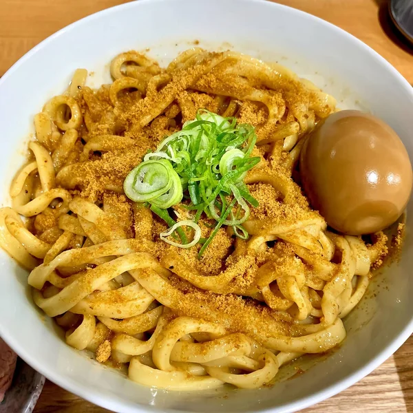 Close up ramen noodles with egg are provided in white bowls. Delicious food concept. Top view.