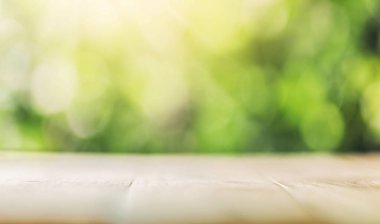 Empty brown wooden table with Fresh and green leaves green bokeh on nature abstract blur background green bokeh from tree.Template up montage for product,Banner or header for advertise on social media