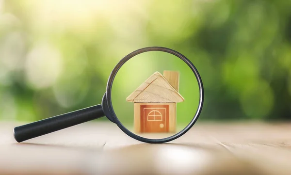 Wooden houses and magnifying glass. Property valuation. Home appraisal. Choice of location for the construction. House searching concept. Search for housing and apartments. real estate and investment.