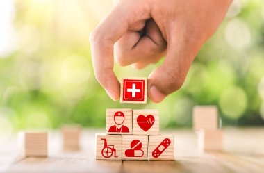 Hand arranged wooden blocks with icons of medical health. health insurance for your health concept. Healthcare medical business, medical technology equipment icon, health care protection concept.