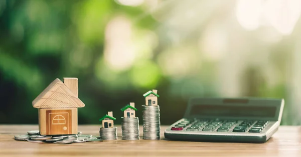 Ev sikkelerin üzerine konur. Bir ev almak için hesaplama konsepti. gayrımenkul, ipotek, gayrimenkul yatırımları ve ev satın almak için tasarruf parası planlamak.