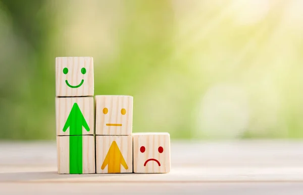 Tahta küp şeklindeki ikon suratlı gülen surat, müşteri değerlendirmelerindeki en iyi iş tecrübesi, memnuniyet araştırması konsepti. Müşteri hizmetleri değerlendirmesi ve tatmin araştırması kavramları