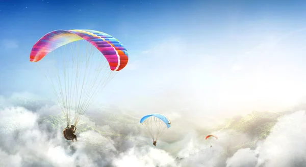 Paragliding multicolor. Paraglider flying over Landscape from the background Beauty nature mountain landscape of the sky. Paragliding Sports. Concept of extreme sport, taking adventure challenge.