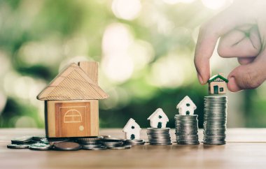 Madeni paraların üzerine yerleştirilen ev, emlak merdiveni, ipotek ve emlak yatırımları için konsept konsepti satın almak amacıyla madeni paradan tasarruf etmeyi planlıyor. bir ev için para biriktirmek ya da yatırım yapmak.