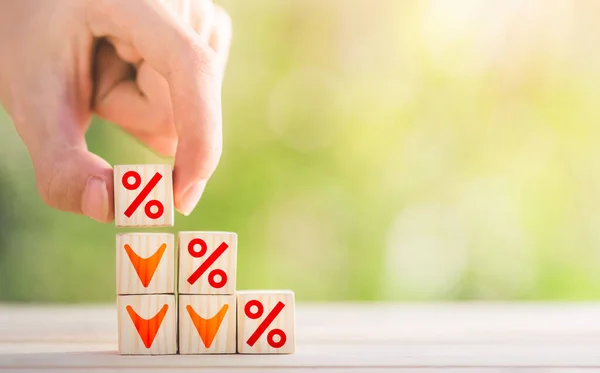 Yüzdelik işareti ve aşağı ok sembolü olan bir basamak merdiven için el yapımı tahta bloklar. İpotek işletmeyi, faiz oranını ve ipotek oranlarını belirler. Faiz oranları değerlendirmesi.