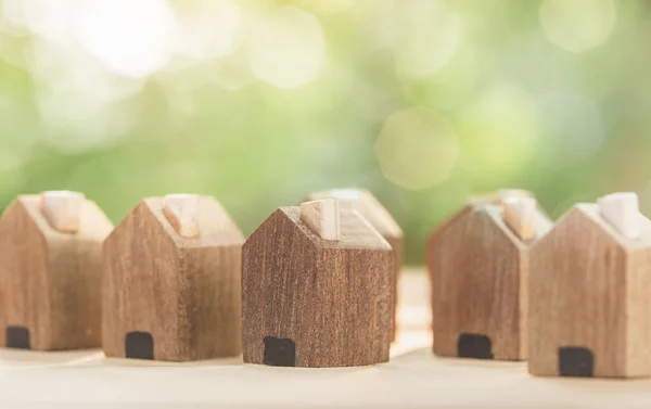 Masanın üzerinde ahşap bir köy ve yeni bir ev inşa etmek için yer var. gayrımenkul, ipotek ve gayrimenkul yatırımları için konsept satın almak ve bir ev için tasarruf parası planlamak.
