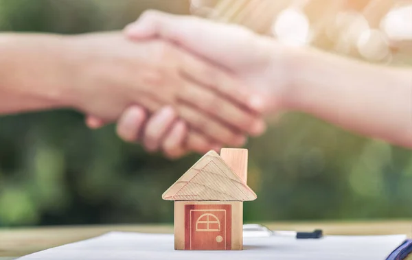 Real estate brokers and clients shake hands after agreeing to buy a home. realty purchase, Bank employees congratulate, Concept mortgage loan approval. planning savings money of coins to buy a home.