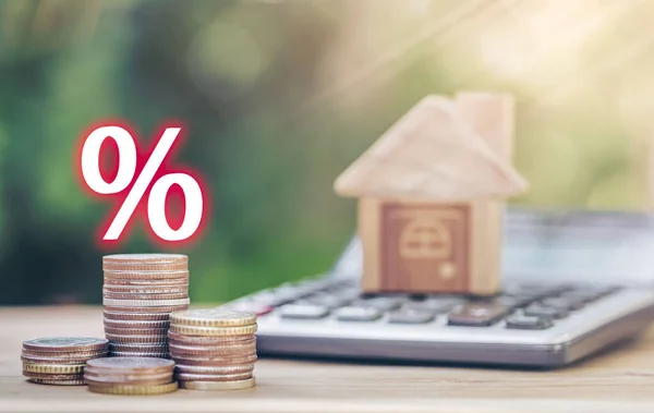 Paralar hesap makinesine istiflenmiş ve faiz ödemelerini hesaplayan bir illüstrasyon içeriyor. gayrımenkul, ipotek ve gayrimenkul için konsept satın almak için madeni paraların tasarrufu planlanıyor.