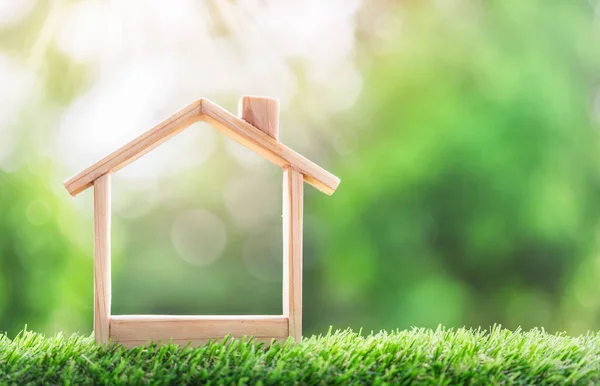 Çimlerin üzerinde ahşap bir ev. Gayrimenkul yatırımı kavramı. gayrımenkul, ipotek ve emlak yatırımları için bir konsept satın almak için tasarruf parası planlamak, bir ev için tasarruf.