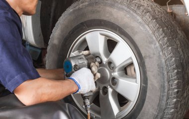 Araç kullanan tamirci, araba lastiği değiştiren tamirci garajdaki lastik sistemini kontrol eden tamirci, uzun bir yolculuktan önce kazaları azaltmak için güvenlik aracı..