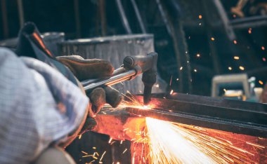 Görüntü Kapat el ağır endüstriyel işçiler metal fabrikası işlemleri üzerinde çalışıyor gaz kesme makinesiyle çeliği keserek kazan fabrikasında kalın çeliği keserek.