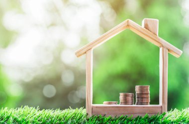 Bozuk paralar çimlerin üzerindeki bir model evin merdiveni. gayrımenkul, ipotek ve emlak yatırımları için bir konsept satın almak için tasarruf parası planlamak, bir ev için tasarruf.