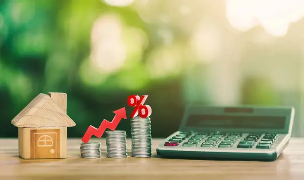 House is placed on the coins. Stacked Coins on wooden table with white illustration shows increasing of interest rates increase. planning savings money of coins to buy a home concept for property.