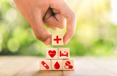 Hand arranged wooden blocks with icons of medical health. health insurance for your health concept. Healthcare medical business, medical technology equipment icon, health care protection concept.