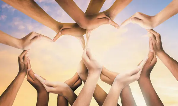 Birlik ve çeşitlilik, takım çalışmasını ve birlikteliği temsil eden destekleyici bir sembol olarak birbirine bağlı farklı bir grup insanın kalbindedir. Ellerden yaratılan sembol ve şekil.