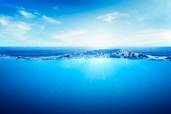 Волны и пузыри синей воды. Белые облака на голубом небе над спокойным морем с солнечным светом, спокойная морская гармония спокойной водной поверхности. Солнечное небо и спокойный голубой океан.