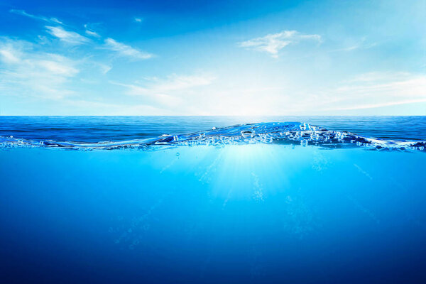 Волны и пузыри синей воды. Белые облака на голубом небе над спокойным морем с солнечным светом, спокойная морская гармония спокойной водной поверхности. Солнечное небо и спокойный голубой океан.